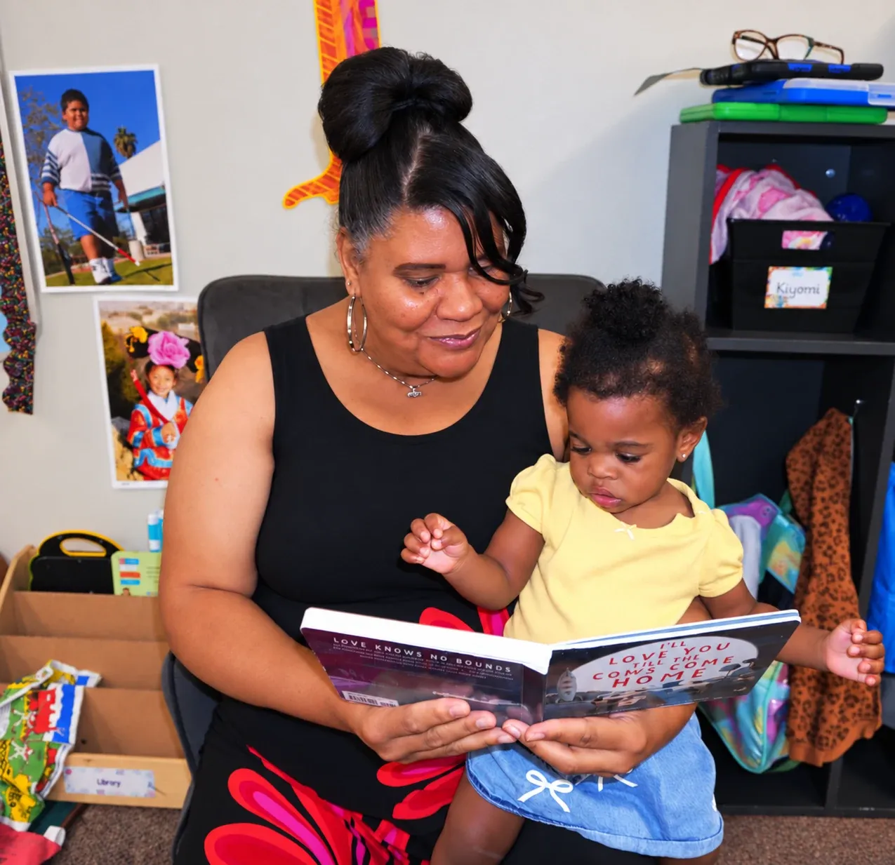 A teacher reads a picture book with a toddler on her lap in a classroom at Chapel Glen Early Learning Academy