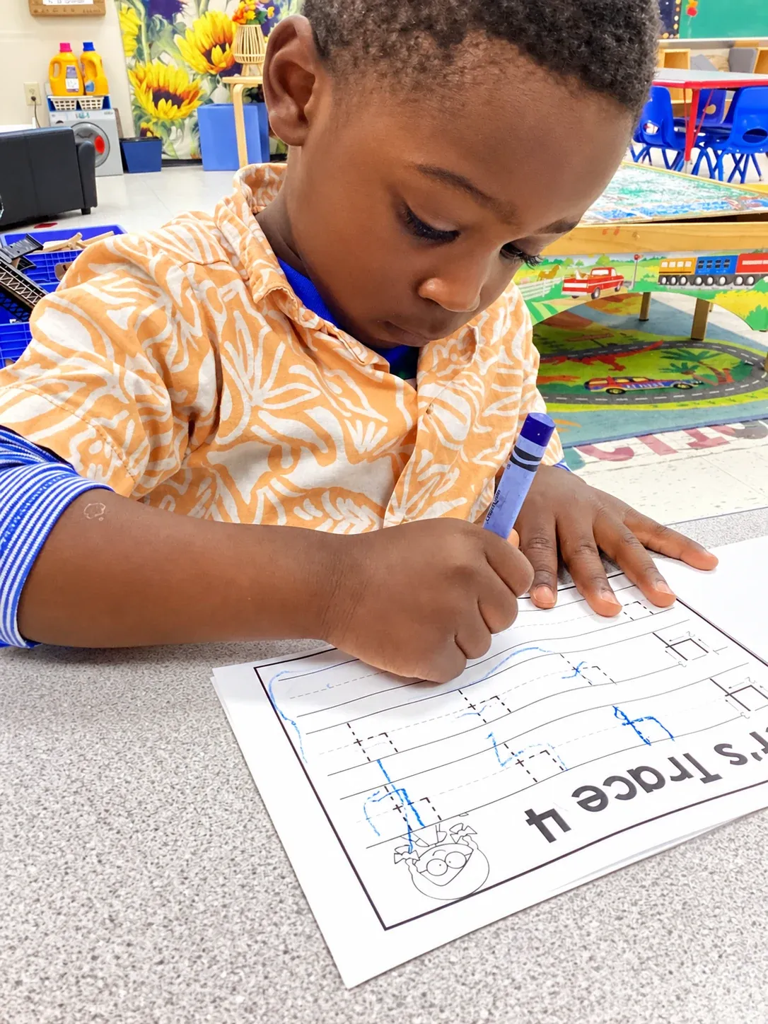 A preschooler traces the number four with a marker