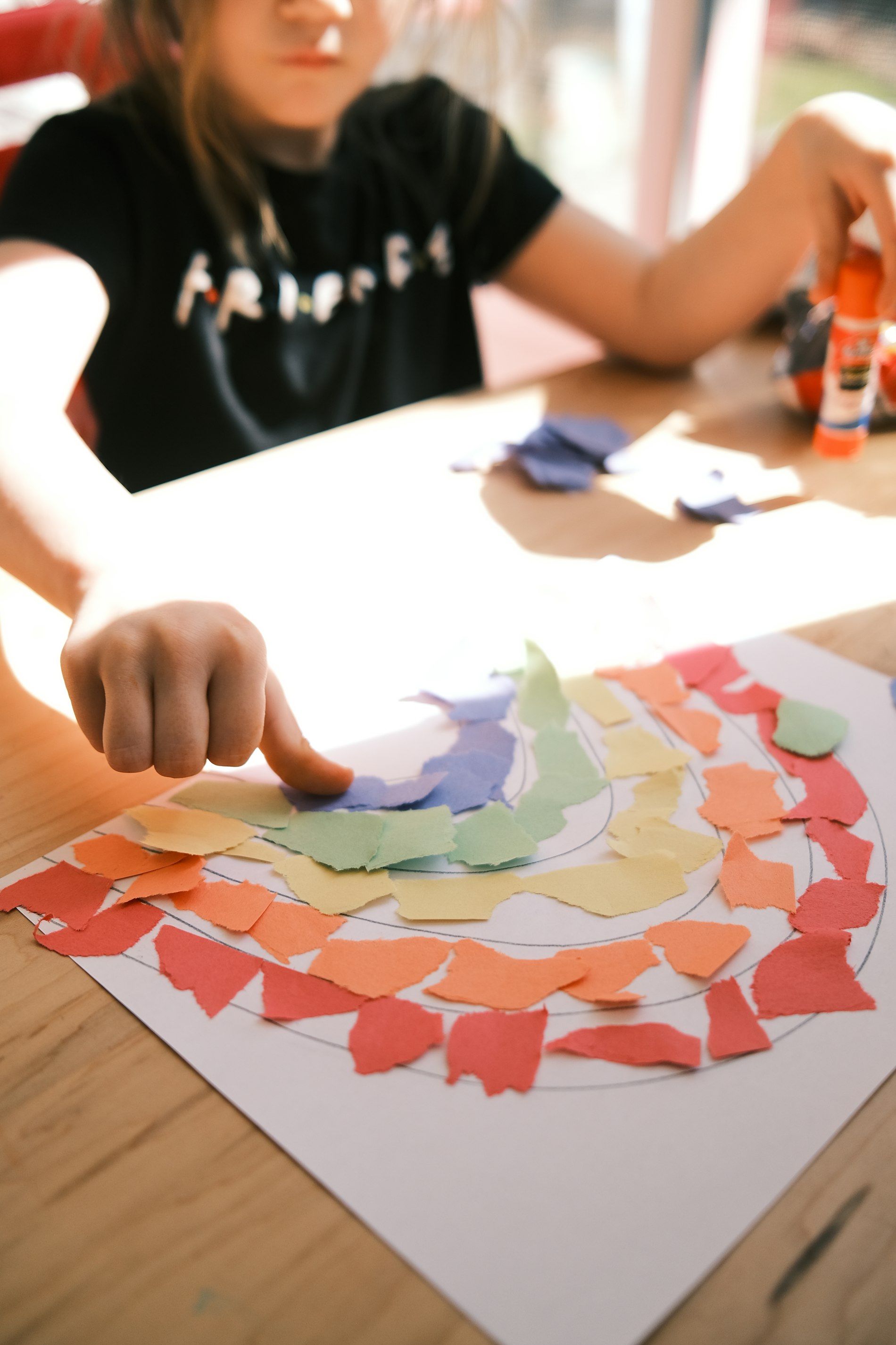 A child creating a paper rainbow craft at Chapel Glen Early Learning Academy